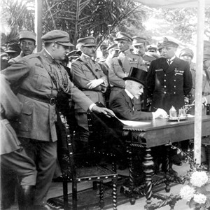 O Presidente da República Manuel Teixeira Gomes, sentado, durante a cerimónia do lançamento da primeira pedra do Monumento aos Mortos da Grande Guerra.