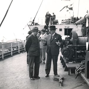 O ministro da Marinha Américo Tomás, à esquerda, conversando com o industrial Manuel de Mello, à direita, durante a sua visita ao navio «Arraiolos».