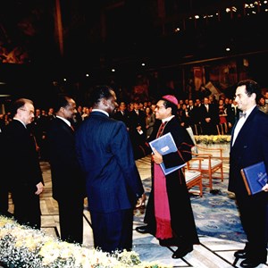 Cerimónia de entrega do Prémio Nobel da Paz a D. Ximenes e José Ramos Horta, em 1996, na Câmara Municipal de Oslo. Cumprimentam: os Presidentes de Portugal, Moçambique e Guiné, respetivamente, Jorge Sampaio, o segundo da esquerda, Joaquim Chissano, o terceiro, e João Bernardo Vieira, o quarto.