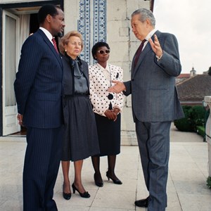 O Presidente da República Mário Soares, à direita, na companhia do Presidente Joaquim Chissano, de Moçambique, na varando do Palácio de Belém. Entre os dois Chefes do Estado: Maria Barroso, à esquerda, e Marcelina Chissano, à direita.