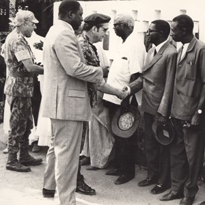 O chefe do Estado-Maior General das Forças Armadas, Francisco da Costa Gomes, acompanhado pelo governador da Guiné, António de Spínola, mais atrás, e por uma terceira pessoa, possivelmente uma autoridade local, que vai apresentando ao chefe do Estado-Maior as pessoas a cumprimentar: habitantes das vilas de Teixeira Pinto e Pelundo. A visita de Costa Gomes à Guiné realizou-se entre 3 e 13 de janeiro de 1973.