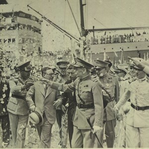 Visita do Presidente da República às colónias de África. O general Óscar Carmona, à frente, de mão levantada, recebe as saudações da população à chegada ao porto do Lobito. É acompanhado pelo ministro das Colónias, Vieira Machado, de chapéu na mão, e outras autoridades.