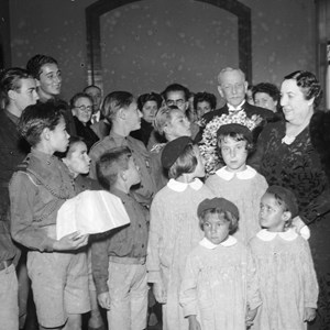 O Presidente da República Óscar Carmona, em segundo plano, com um ramo de flores oferecido por um grupo de crianças da Mocidade Portuguesa, no dia do seu aniversário; à frente, à direita, a mulher do Chefe do Estado, Maria do Carmo Carmona.
