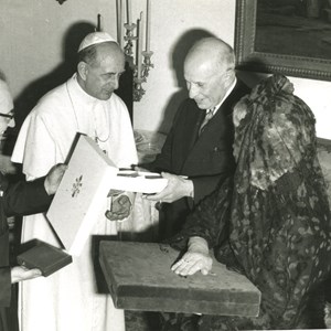 Visita do Papa Paulo VI a Portugal. Cerimónia habitual de troca de presentes entre chefes de Estado: o Sumo Pontífice, à esquerda, de branco, entrega ao Presidente da República Américo Tomás, à direita, a sua lembrança, acompanhado pela mulher, Gertrudes Tomás.