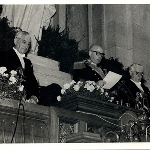 Tomada de posse do Presidente da República Américo Tomás, ao centro, discursando na Assembleia Nacional (atual Assembleia da República). Na tribuna, ladeando o novo Chefe do Estado, encontram-se: o presidente do Conselho de Ministros, Oliveira Salazar, à esquerda, e o presidente da Assembleia Nacional, Albino dos Reis, à direita.