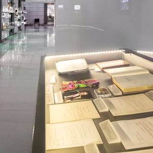 Em primeiro plano, vitrina com fotografias, documentos e condecorações, pertencente ao núcleo sobre os poderes do Presidente da República. Ao fundo, presentes de Estado.