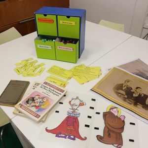 Oficina «Acrescenta um ponto». Materiais utilizados na oficina: gavetas de escrita criativa, etiquetas, personagens, imagens de arquivo e as obras «Contos Tradicionais do Povo Português» e «Tristão o Enamorado», de Teófilo Braga.