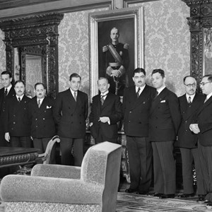 O Presidente da República, Óscar Carmona, com os membros do Governo que lhe foram apresentar cumprimentos pelo aniversário. Da esquerda para a direita: capitão Fernando Santos Costa, Rebelo de Andrade, João da Costa Leite, Rafael Duque, Teotónio Pereira, Carneiro Pacheco, Manuel Rodrigues, António de Oliveira Salazar, general Óscar Carmona, comandante Ortins de Bettencourt, major Joaquim Abrantes e Vieira Machado.