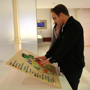 Visitante cego tacteando uma maquete relevada do Palácio de Belém.