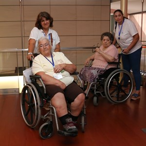 Visitantes de cadeira de rodas durante visita guiada ao Museu.