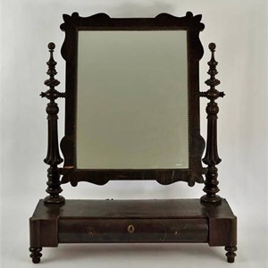 Modelo de espelho-toucador muito usado nos quartos, sobre uma mesa, o «toucador», ou sobre uma cómoda. Podia ter junto uma bacia, jarro e saboneteira, para a higiene.